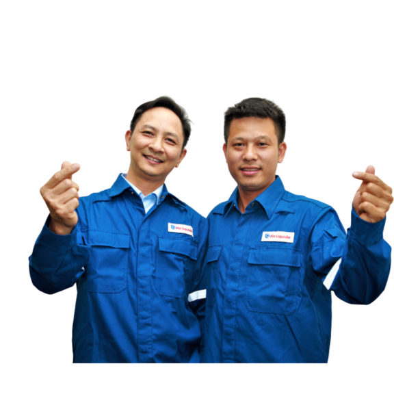 Two men's employees wear an Air Liquide's suit and are making a vietnameese heart with their fingers